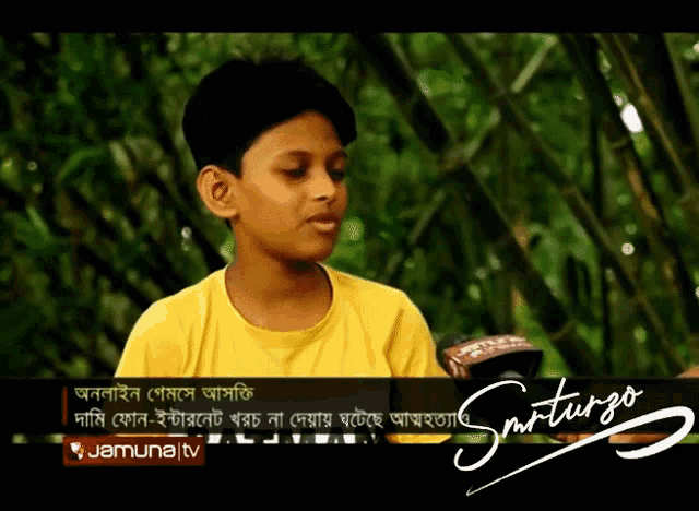 a young boy in a yellow shirt is being interviewed by a reporter for jamuna tv