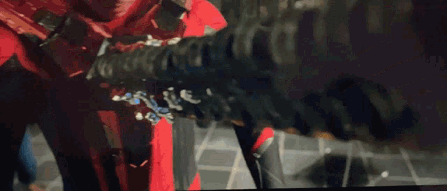 a man in a red costume is holding a sword