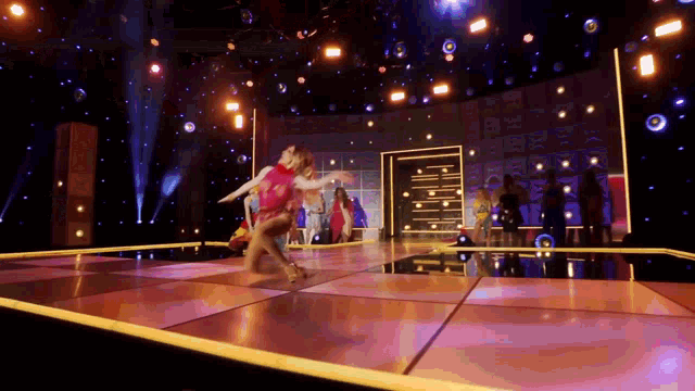 a group of people are dancing on a stage with a sign that says ' i love you ' on it
