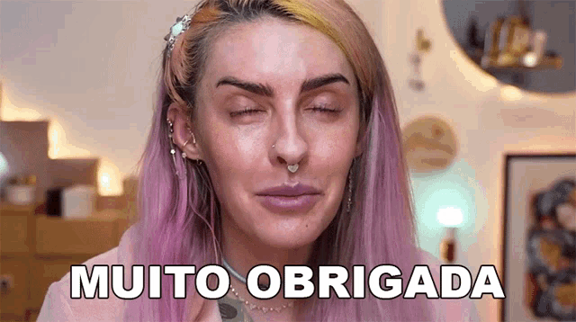 a woman with purple hair and a nose ring says muito obrigada .