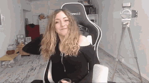 a woman is sitting in a chair with the word newskill on it