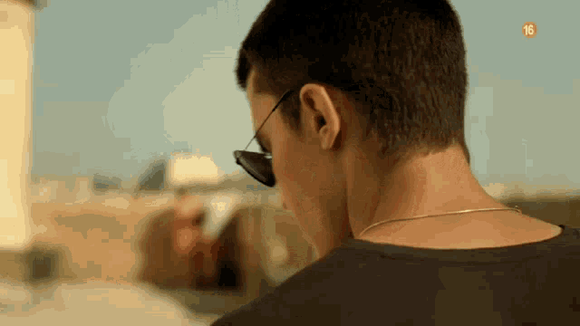 a close up of a man wearing sunglasses and a chain around his neck