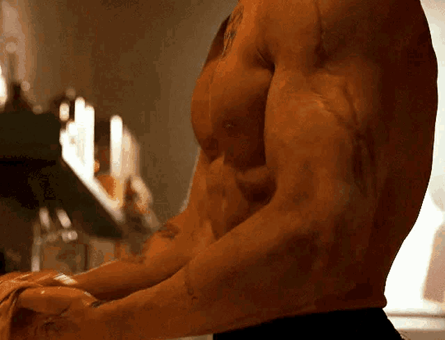 a man without a shirt has a tattoo on his arm that says ' x '