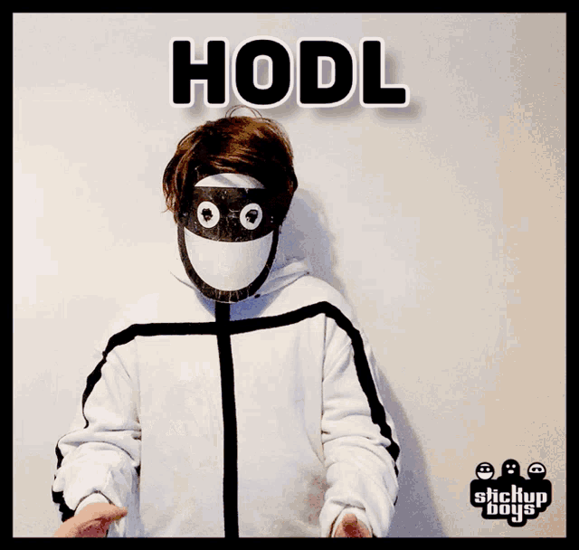 a person wearing a mask is holding a blue book and the word hodl is above him