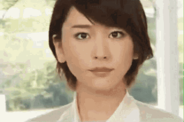 a close up of a woman 's face with a white shirt on .