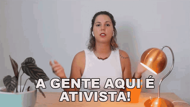 a woman sitting at a desk with a lamp and the words " a gente aqui e ativista "