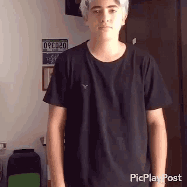 a young man wearing a black t-shirt has a license plate that says ore020