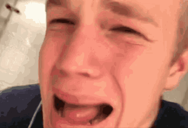 a close up of a man 's face with his eyes closed and his mouth open