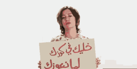 a woman is holding a sign with arabic writing
