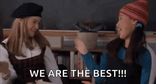a couple of girls are sitting next to each other in a classroom .