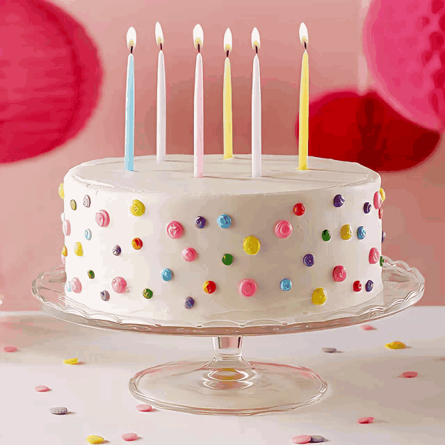 a birthday cake with candles and candy dots on it