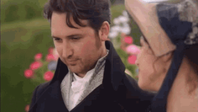 a man and a woman are standing next to each other and looking at each other