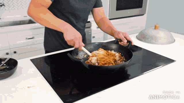 a man is stirring food in a frying pan on a stove top with the words made in animatica below him