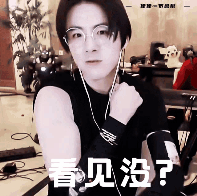 a man wearing glasses and a black shirt with chinese writing on the bottom right