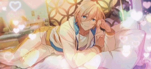 a man is laying on a bed with hearts around him .