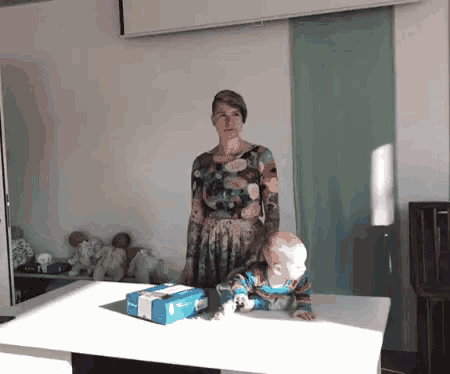 a woman standing next to a baby and a box that says dhl