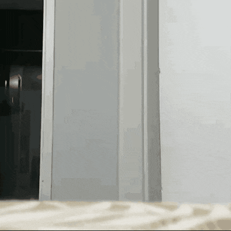 a white door is open to a room with a couch in the foreground