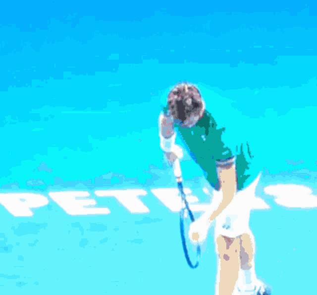 a man holding a tennis racquet on a blue court with the word pete 's in white letters