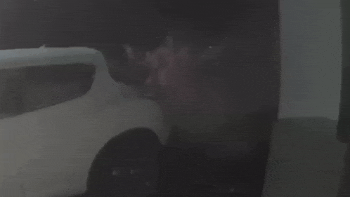 a white car is parked in a dark room .