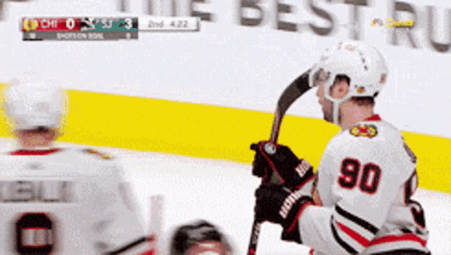a hockey player with the number 90 on his jersey stands on the ice