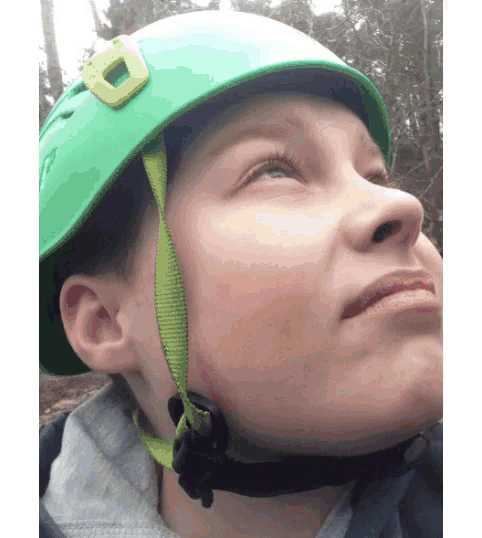 a young boy wearing a green helmet looks up at something