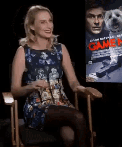a woman sits in front of a screen that says game