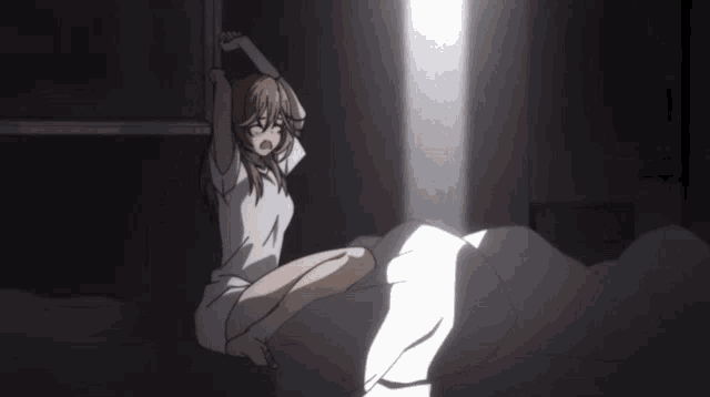 a girl is sitting on a bed with her eyes closed