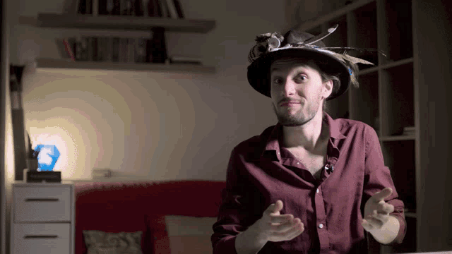 a man wearing a hat with feathers on it is talking