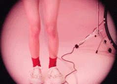 a woman wearing red socks and white sneakers is standing in front of a drum set