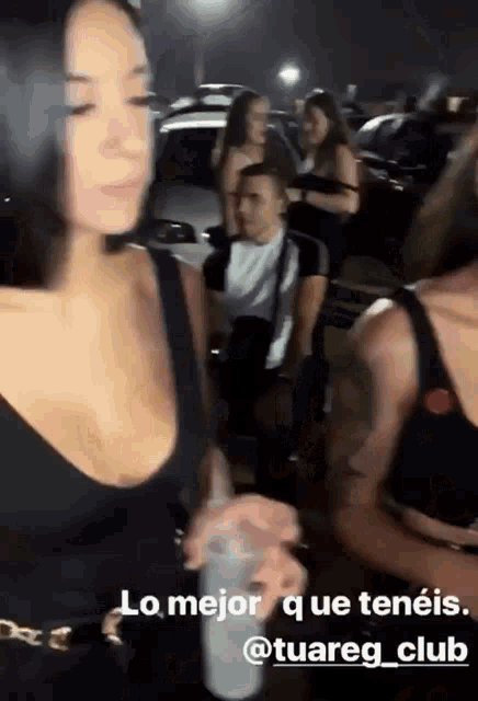 a woman in a black top is holding a cup with the words lo mejor que tenéis written below her