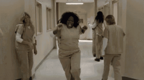 a group of women are dancing in a hallway .