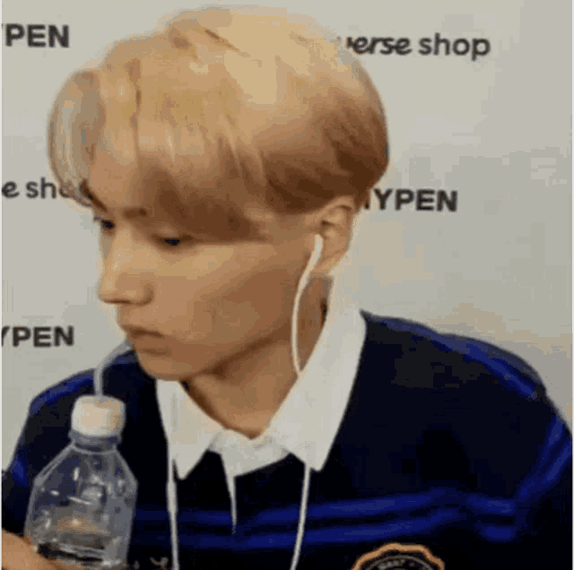 a man wearing headphones and holding a bottle of water .