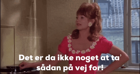 a woman in a pink dress is standing in front of a window and says det er da ikke noget at ta