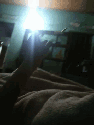 a person is standing in a dark room with a light shining through the window