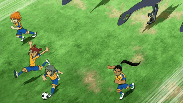 a group of soccer players are playing on a field with a tv screen behind them that says tv tokyo
