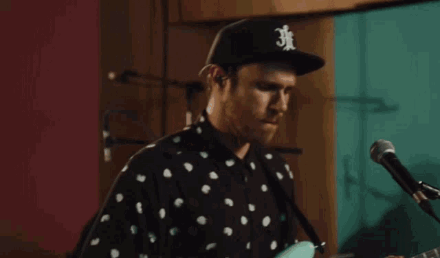 a man singing into a microphone while wearing a hat that says 3f