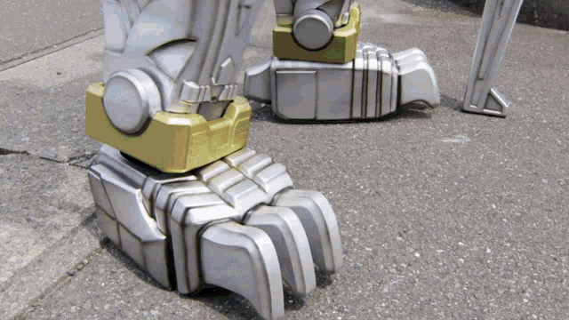 a close up of a robot 's feet with a green button on the side .