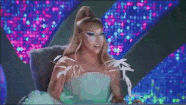 a woman is dancing on a stage with a green light in the background .
