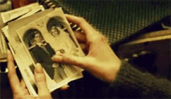 a person holding a picture of a man and woman