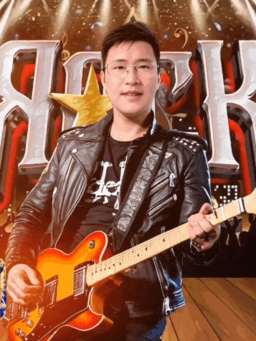 a man in a leather jacket is playing an electric guitar