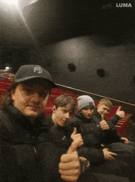 a group of young men are sitting in a theater watching a movie and the word life is on the bottom left