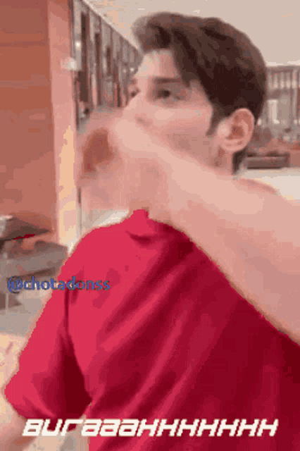 a man in a red shirt is covering his mouth with his hand while a gif is displayed