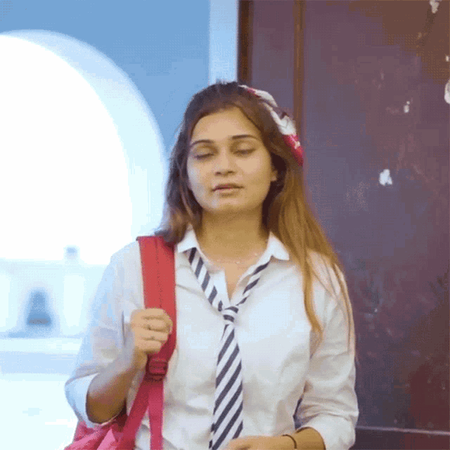 a girl wearing a white shirt and striped tie