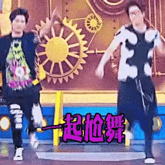 a couple of men are dancing on a stage in front of a sun and gears .
