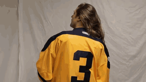a person is wearing a yellow jersey with the number 3 on the back