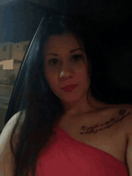 a woman in a red dress has a tattoo on her chest