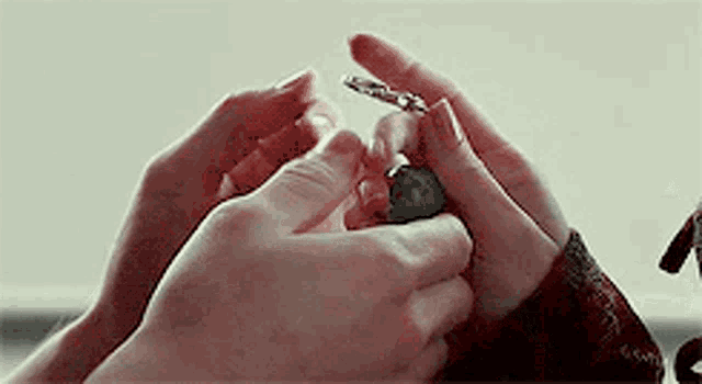 a person is holding a key in their hands .