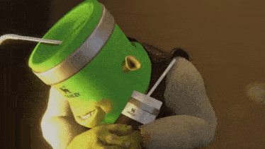 shrek is holding a green stanley container with a straw