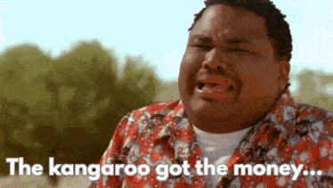 a man in a red shirt is crying with the words the kangaroo got the money behind him
