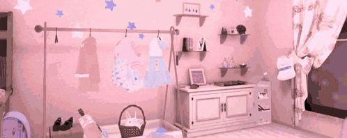 a pink room with clothes hanging on a rack